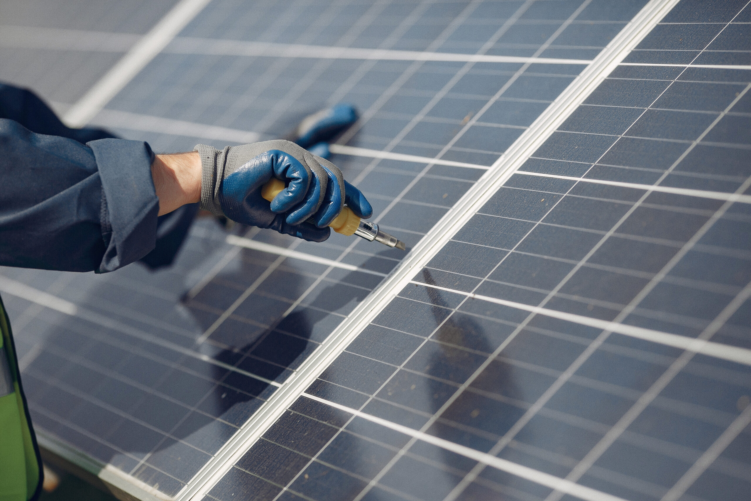 man in a white helmet near a solar panel